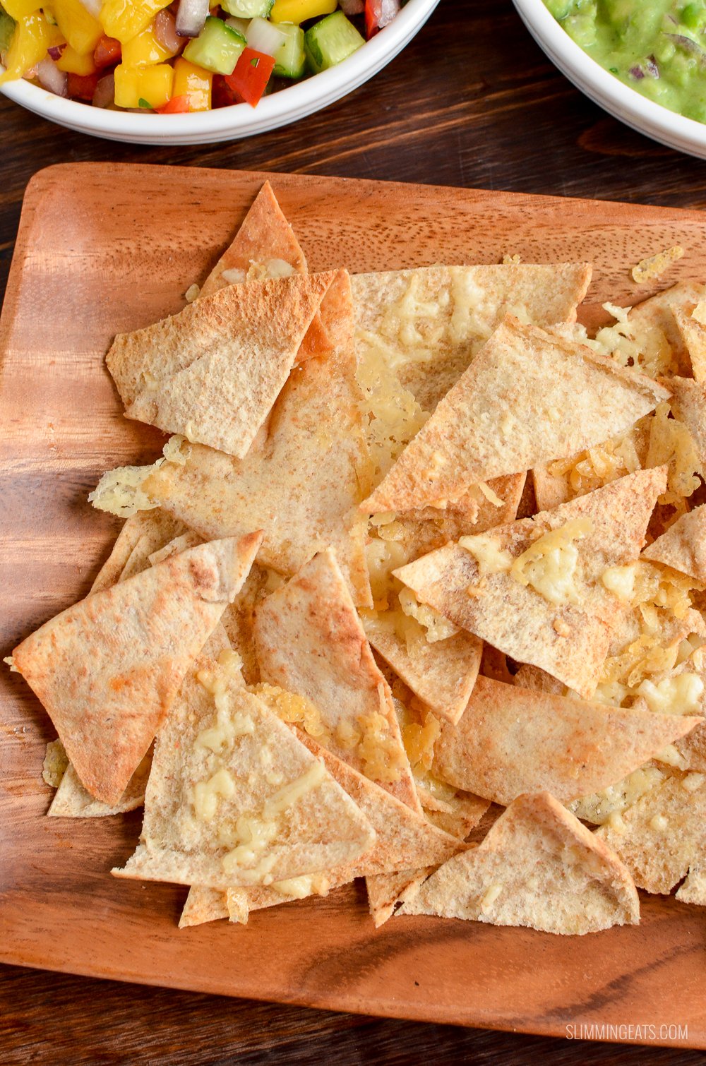 close up of cheddar pita chips on wooden plate