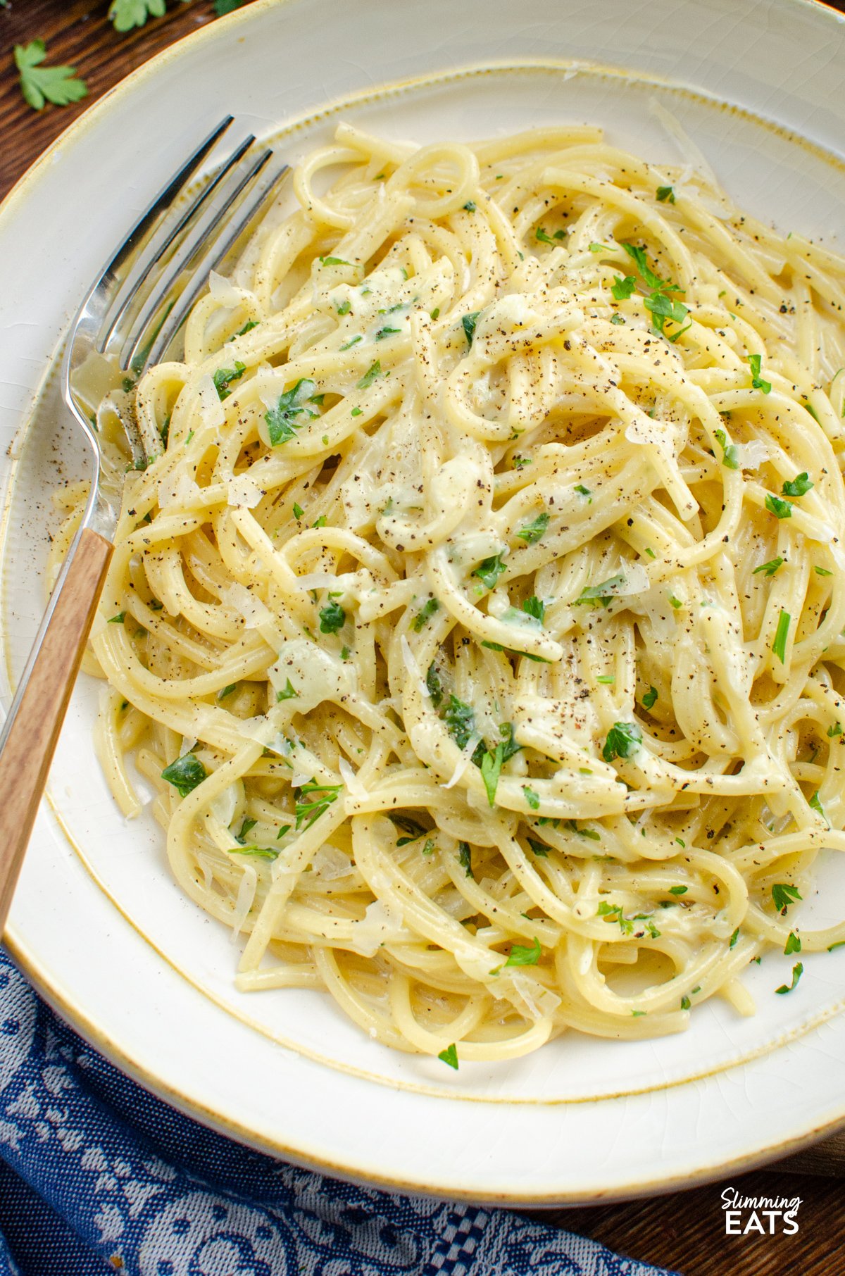 Tuck into a bowl of this irresistibly creamy garlic pasta — a quick, fuss-free one-pot dish that’s perfect for busy evenings. Made with simple, everyday ingredients and ready in under 20 minutes, it’s the kind of comforting meal the whole family will happily dive into. close up of Creamy Garlic Pasta in a white bowl with yellow rim, fork place in bowl on left hand side