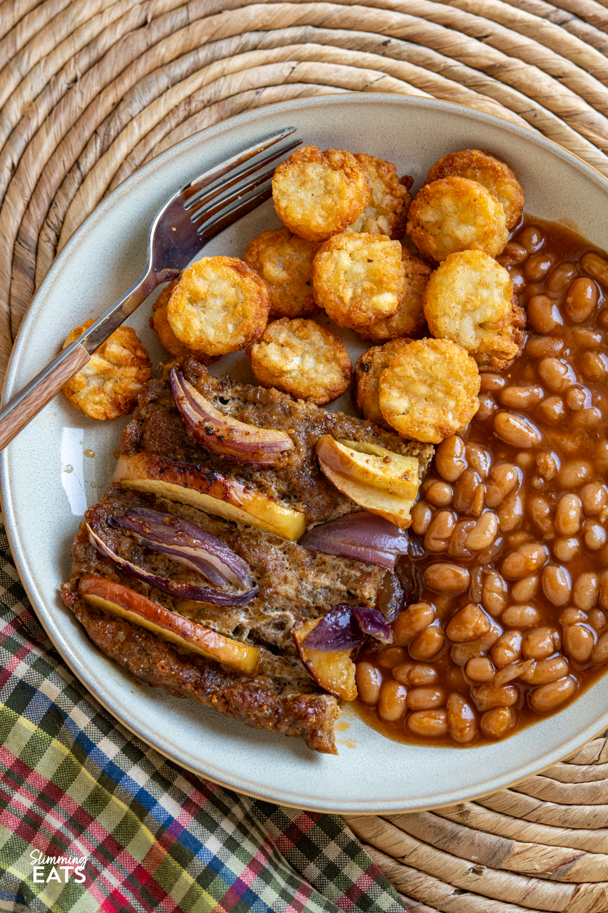 apple and red onion pork apple squares on plate with mini hash browns and baked beans