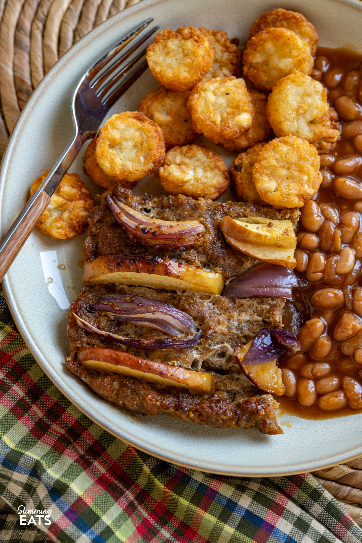 apple and red onion pork apple squares on plate with mini hash browns and baked beans