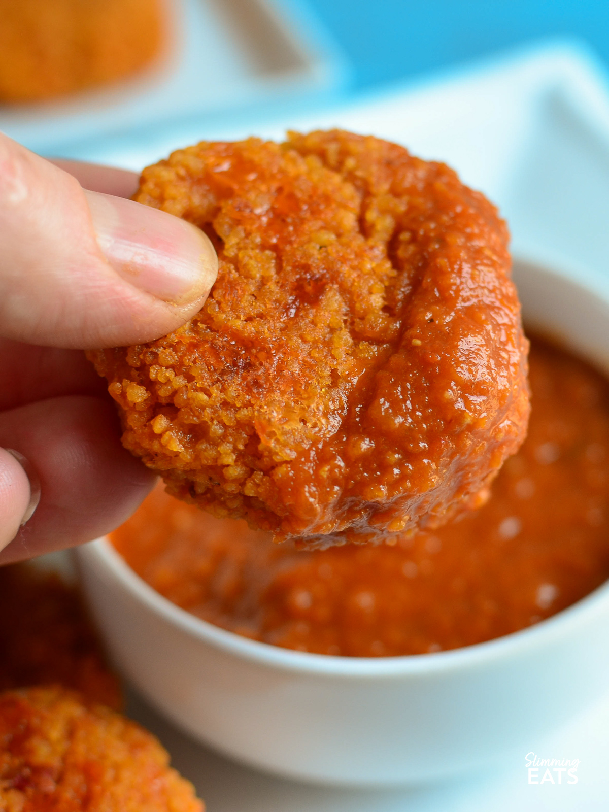 Cheesy Couscous Bite being dipped in  Tomato Dip