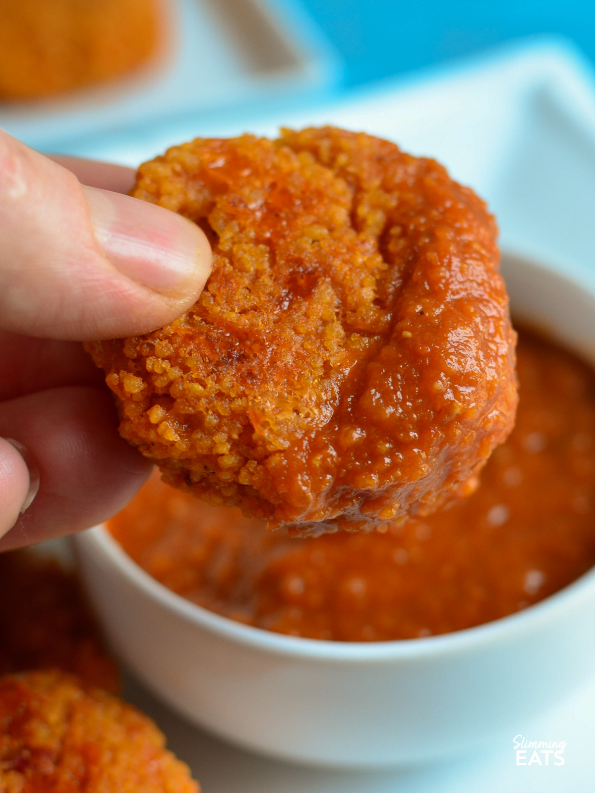 Cheesy tomato couscous bites with delicious tomato dip - great for lunch with some additional picky plate items or as an appetizer. Cheesy Couscous Bite being dipped in Tomato Dip