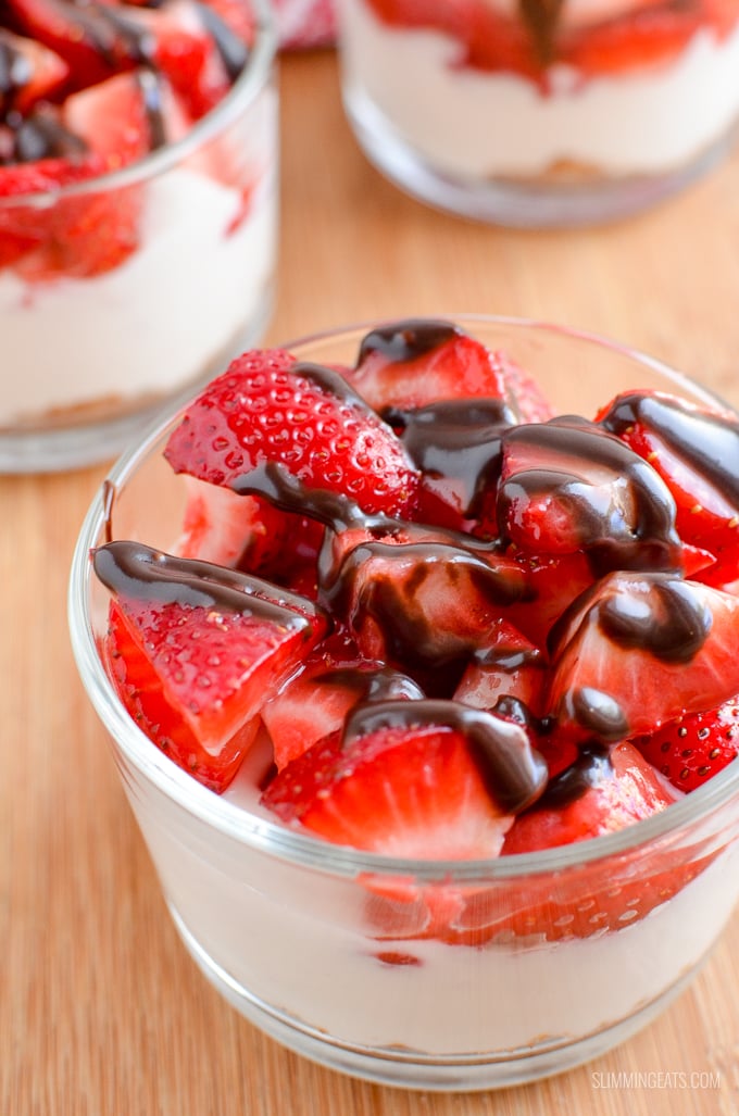 Strawberry Topped Greek Yoghurt Style Cheesecakes - Enjoy one of these delicious Strawberry Cheesecakes that are super quick to make and a delicious treat. Slimming Eats and Weight Watchers friendly close up strawberry Greek yoghurt cheesecake in glass dish