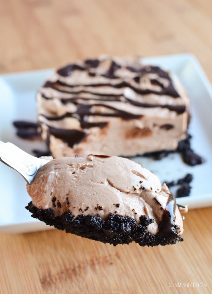 Yummy Chocolate No Bake Cheesecake - with an Oreo biscuit base, perfect for any night of the week. spoon with some chocolate cheesecake on it, from a mini cheesecake on white plate