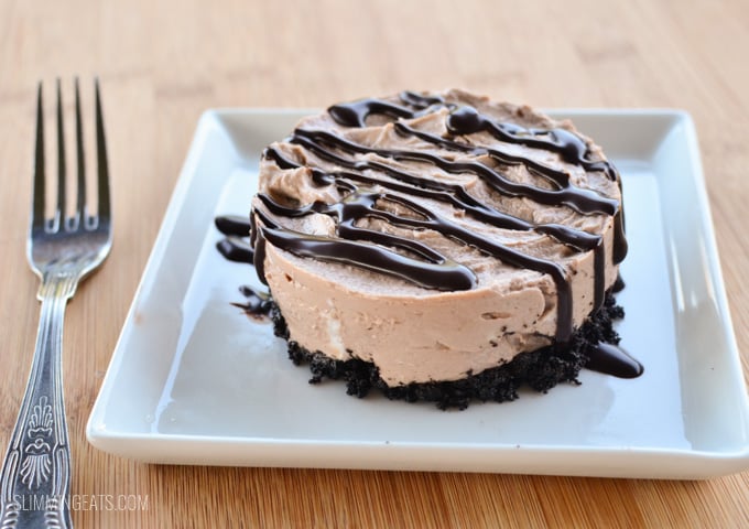 Yummy Chocolate No Bake Cheesecake - with an Oreo biscuit base, perfect for any night of the week. Chocolate no bake cheesecake on white plate with chocolate drizzle