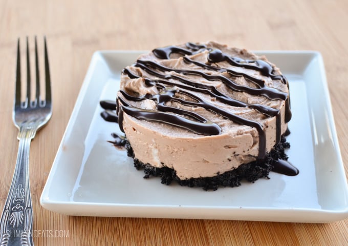 Chocolate no bake cheesecake on white plate with chocolate drizzle