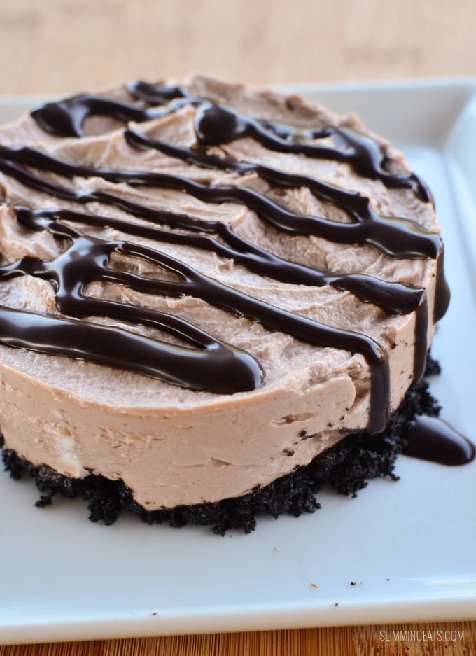 Yummy Chocolate No Bake Cheesecake - with an Oreo biscuit base, perfect for any night of the week. chocolate mini no bake cheesecake on white plate with chocolate drizzle