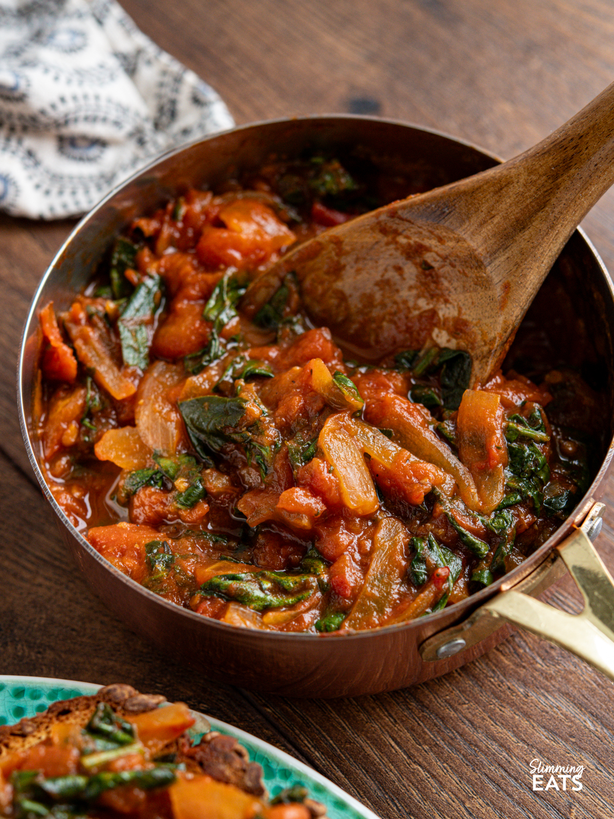 balsamic tomatoes and spinach in a mini copper saucepan with wooden spoon