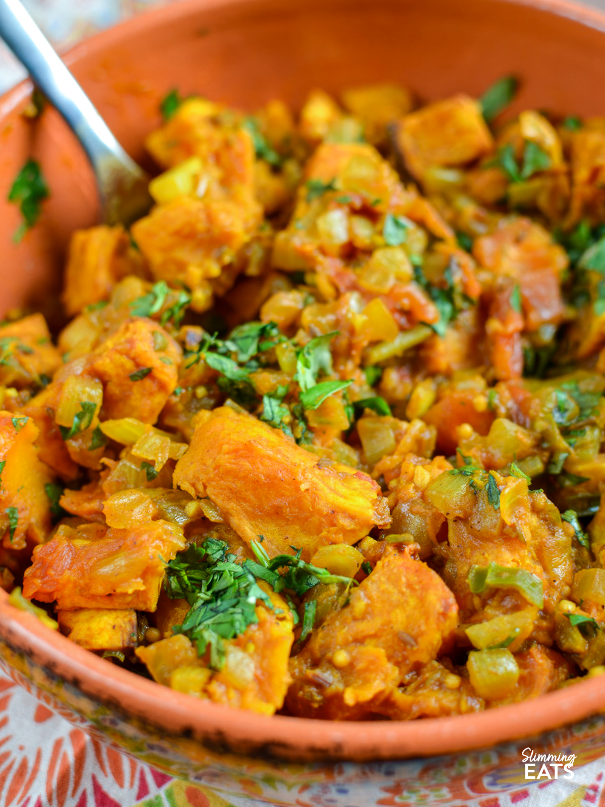 butternut bombay squash in a orange ceramic dish with a handle