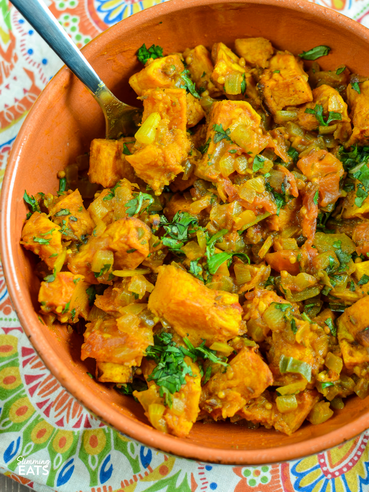 butternut bombay squash in a orange ceramic dish with a handle