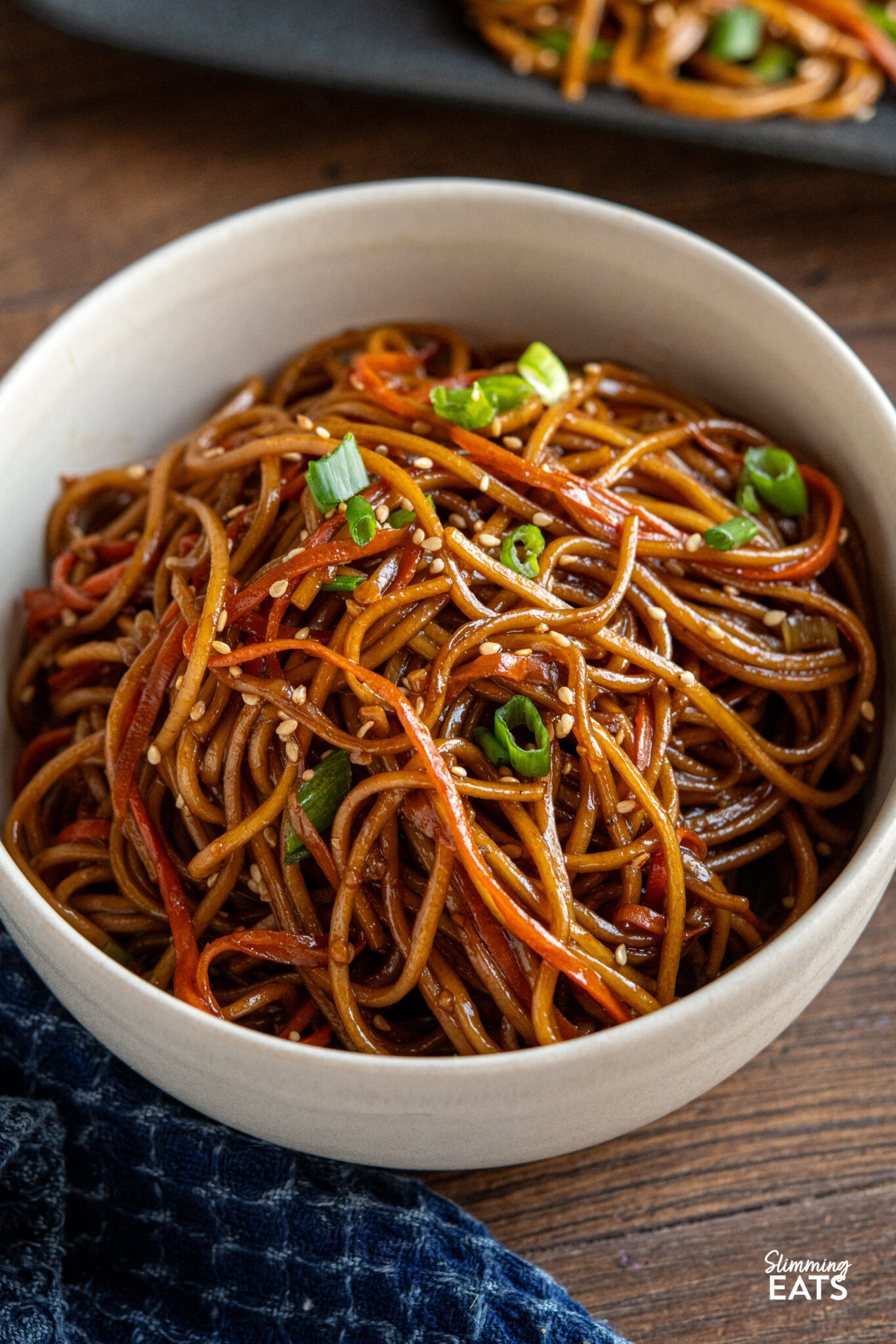 close up of Garlic Sesame Carrot and Noodles in a cream bowl