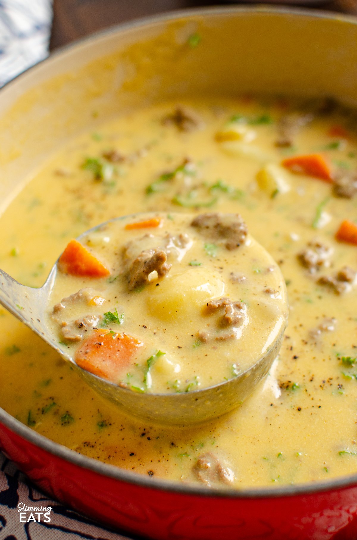 cheeseburger soup in cerise cast iron pot with ladle