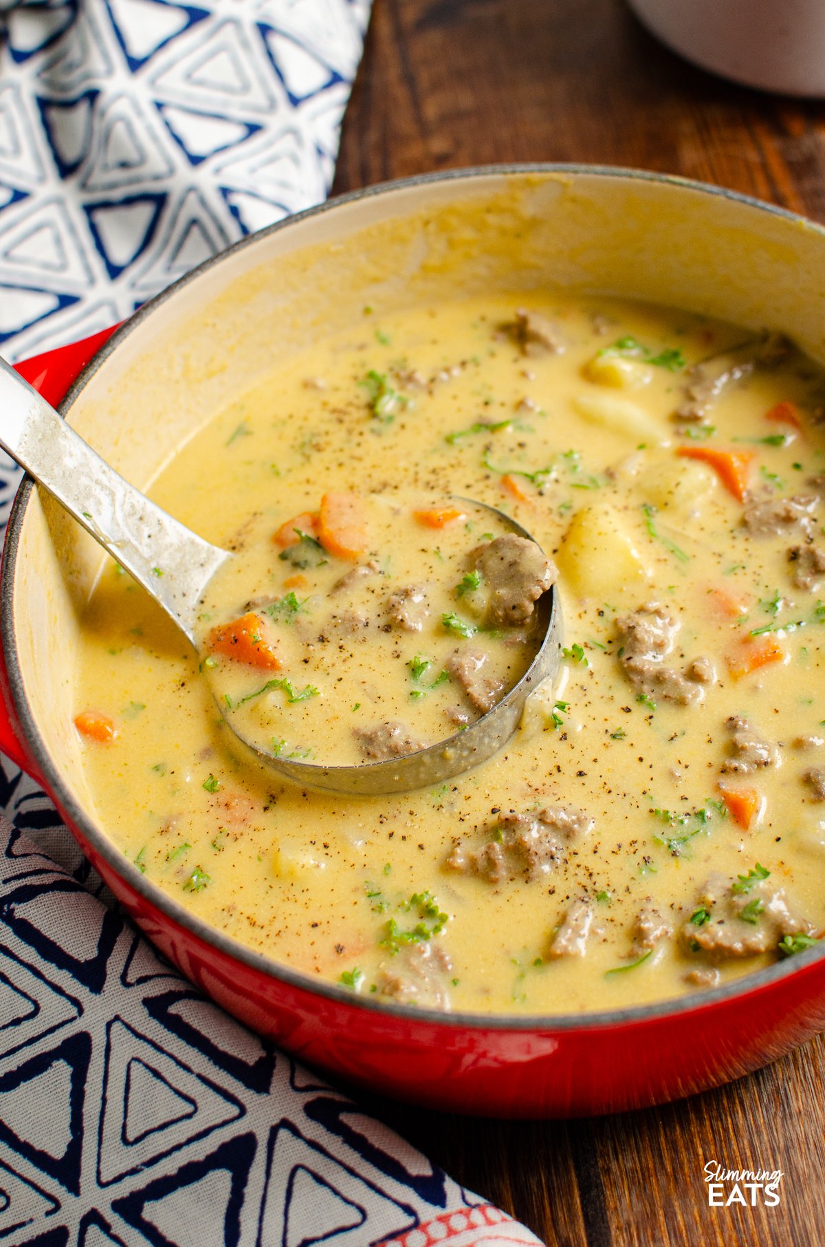 cheeseburger soup in cerise cast iron pot with ladle