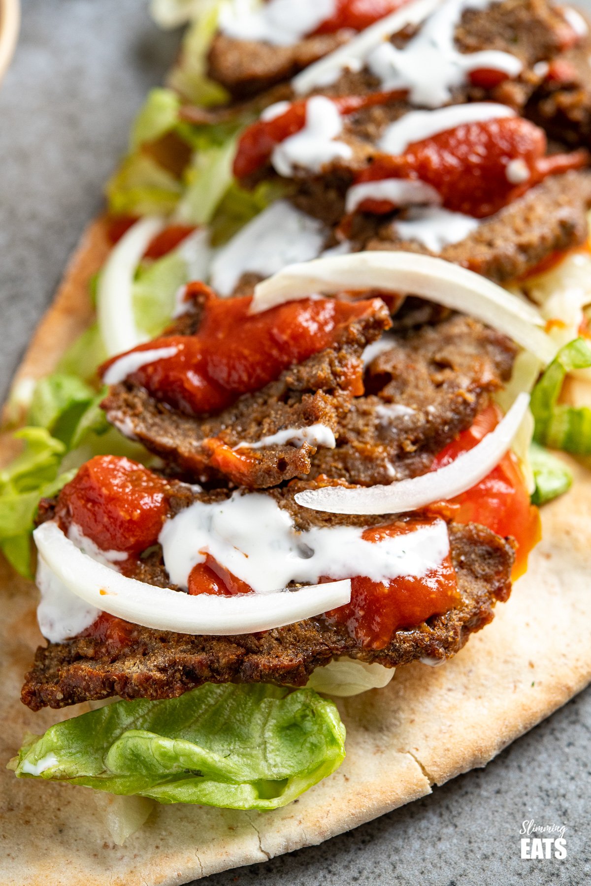 Homemade Doner Kebab Fakeaway Recipe - a delicious homemade version of a popular fakeaway dish, complete with garlic and chilli sauce. It's delish!! #slimmingeats #weightwatchers close up of homemade doner kebab