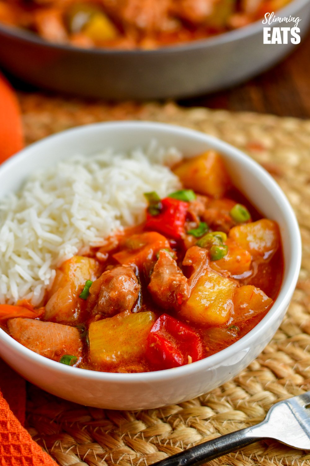 close up of instant pot sweet and sour chicken in white bowl with white rice