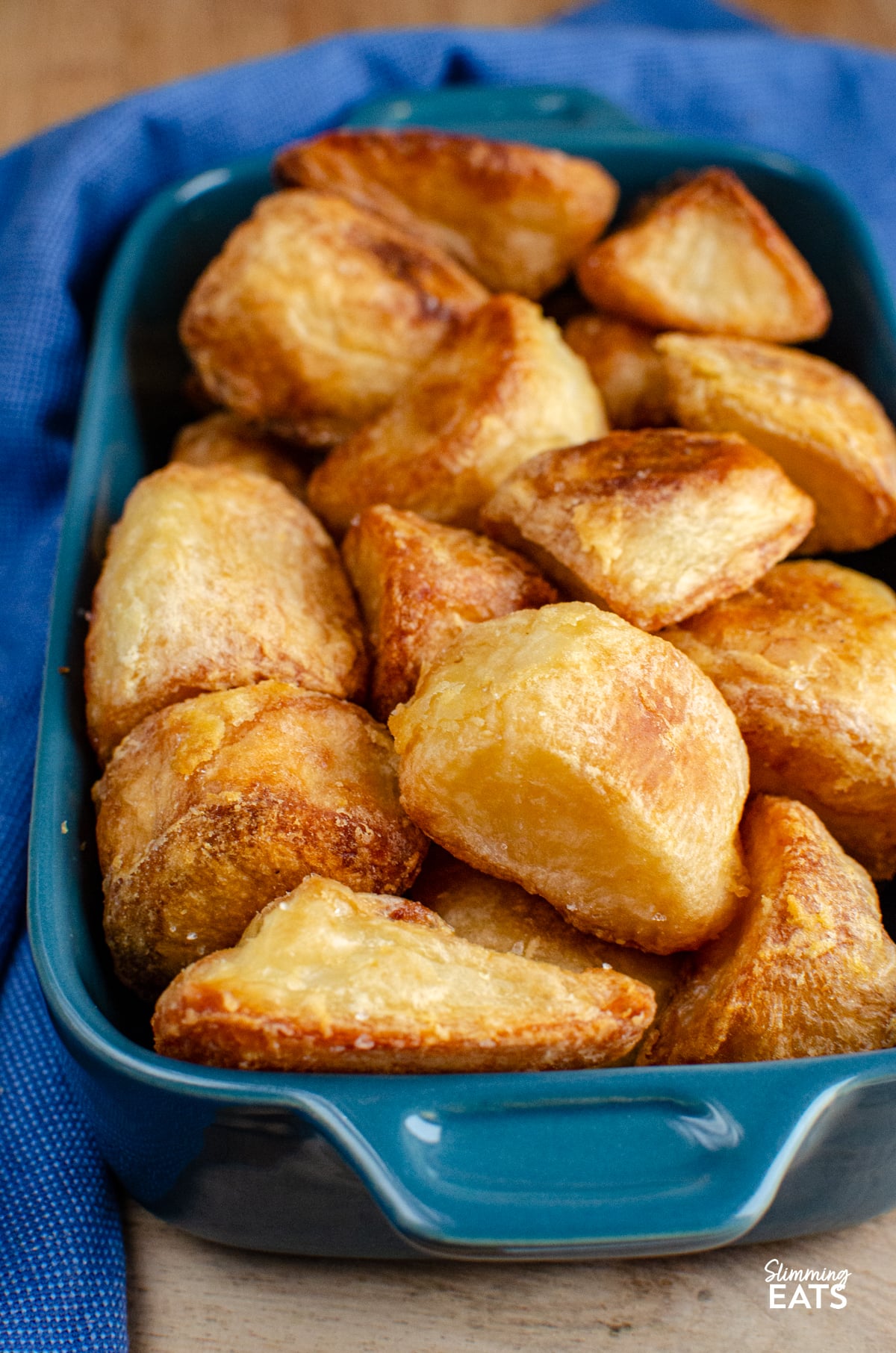 cooked roast potatoes in blue baking dish