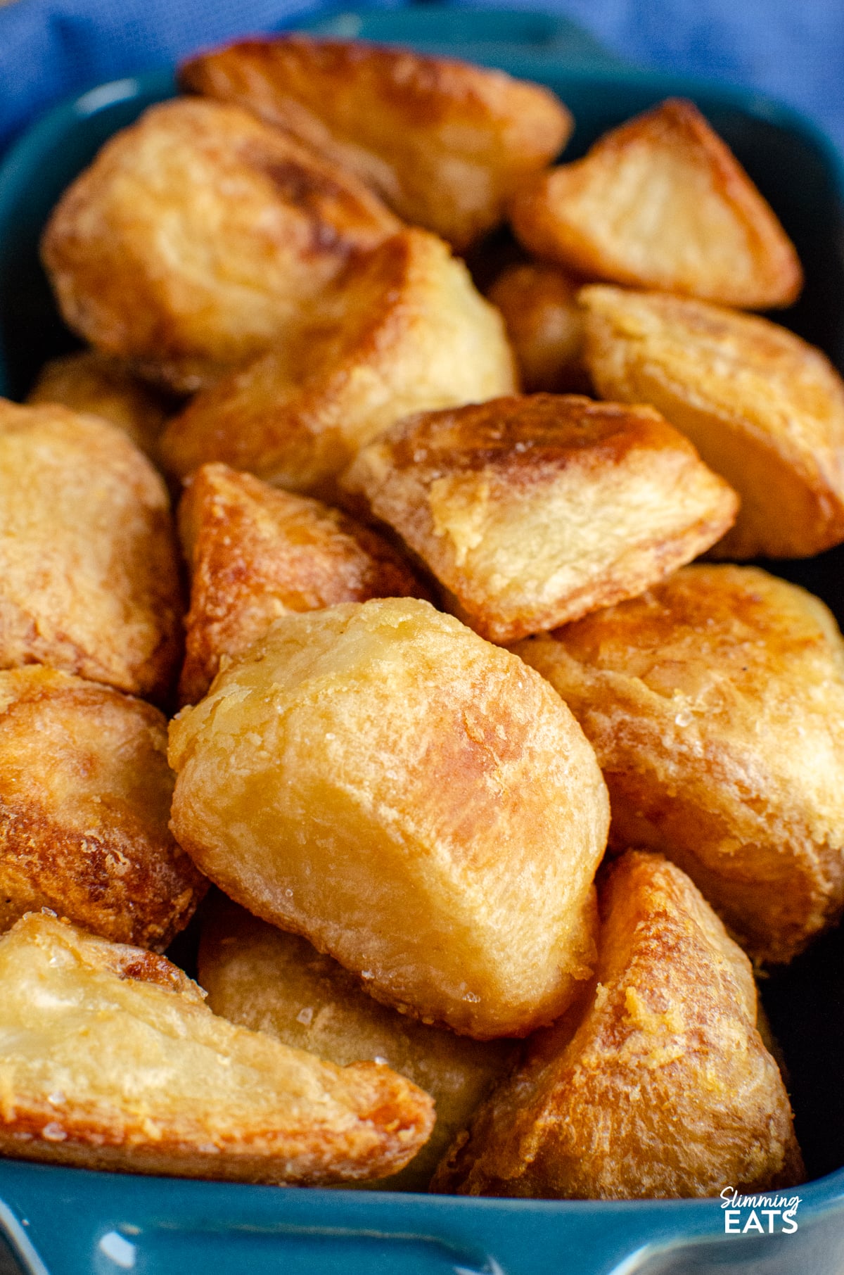 cooked roast potatoes in blue baking dish