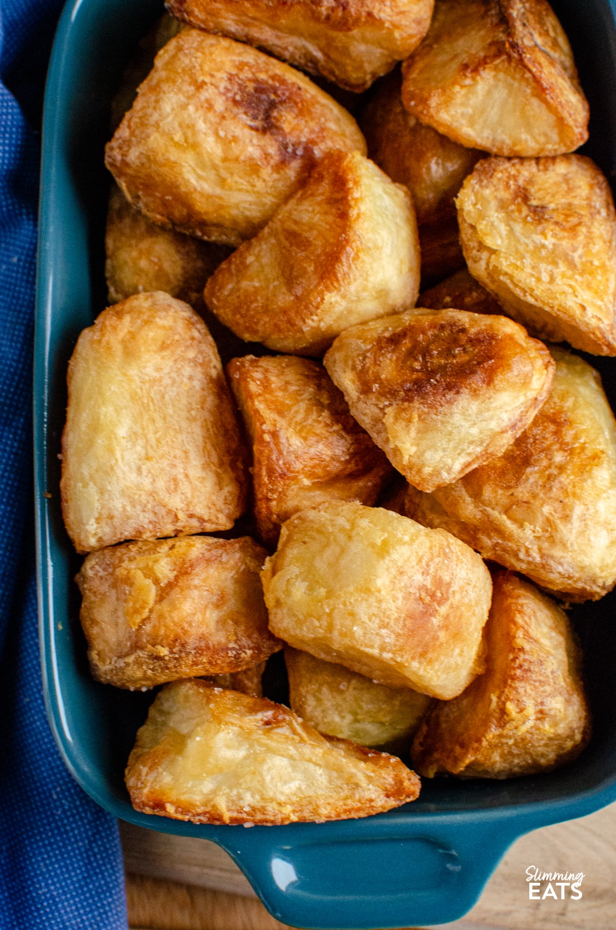 cooked roast potatoes in blue baking dish