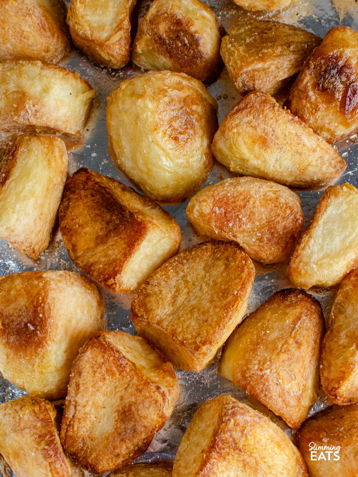 cooked roast potatoes on foil lined baking tray