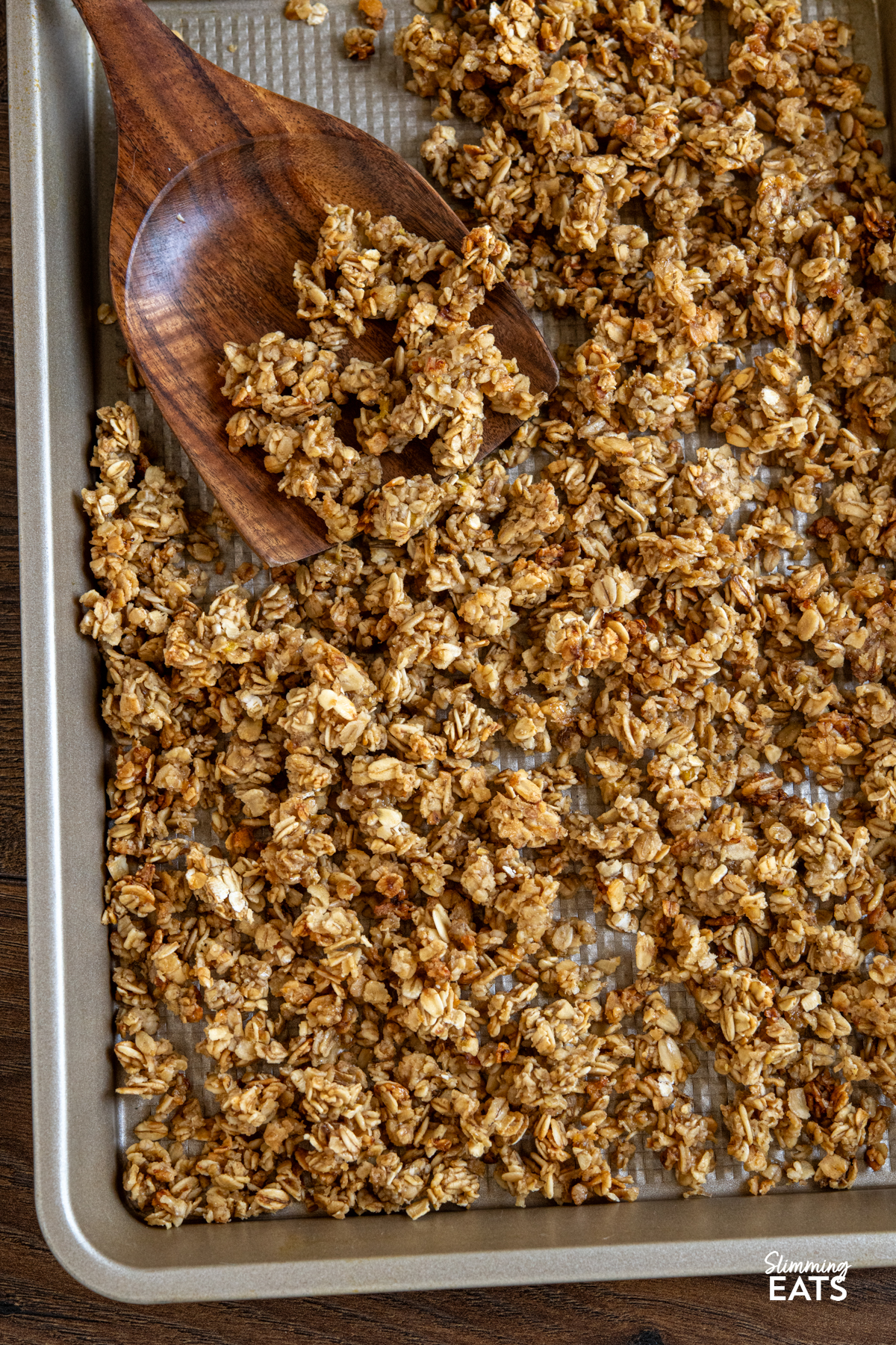 Indulge in the delightful flavours of this Banana Granola, a nutritious and tasty option that's perfect for kick-starting your day or as a scrumptious dessert. Crafted with wholesome oats, ripe bananas, and a touch of maple syrup, this granola is a fantastic low-calorie alternative that doesn't skimp on taste. homemade banana granola on a baking tray