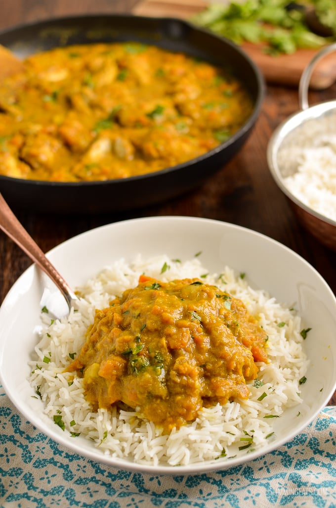 spoon in a bowl of Coconut Chicken and Sweet Potato Curry with rice