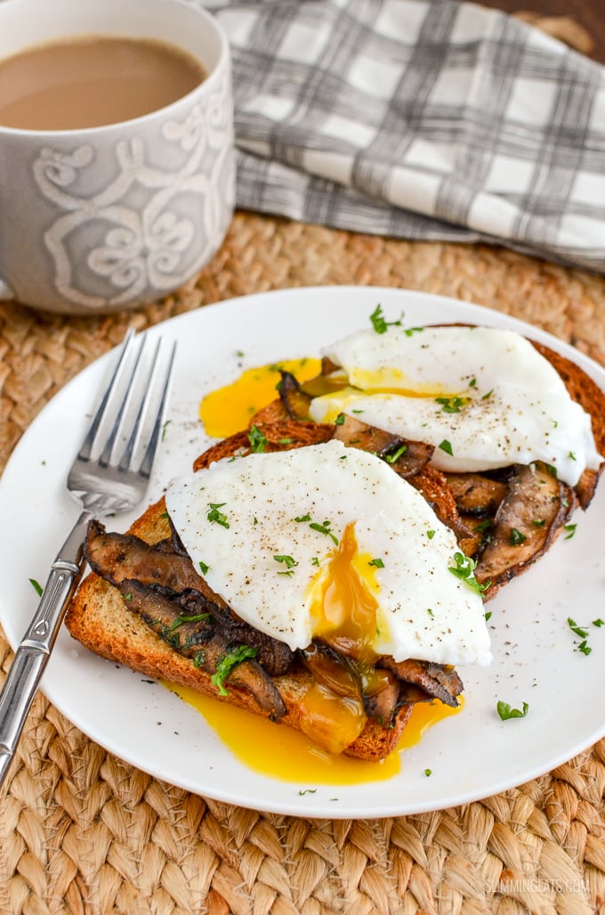 poached eggs over garlic mushrooms on toast with parsley and a mug of coffee