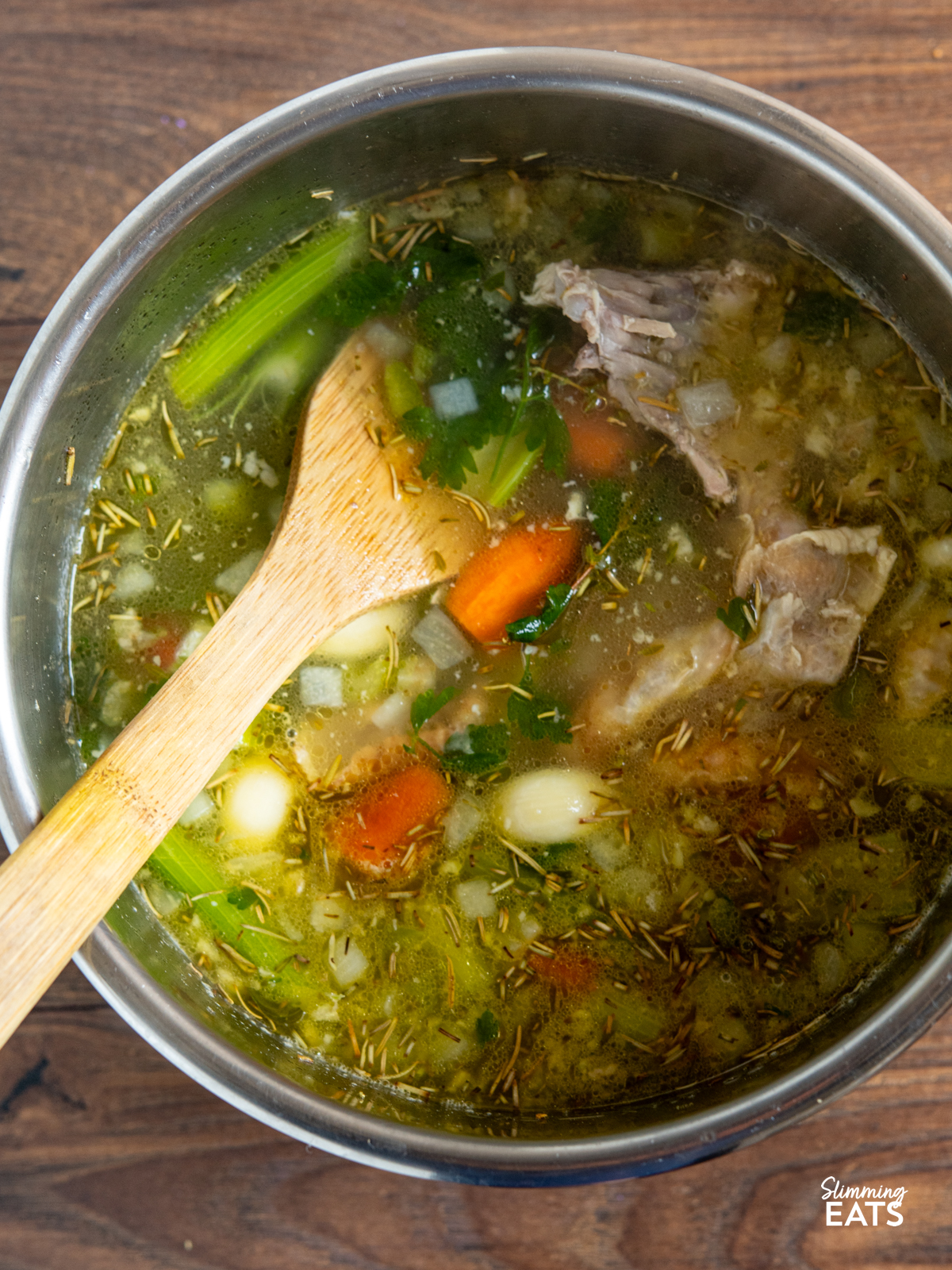 cooked ingredients for homemade chicken bone broth in the pot of a pressure cooker 