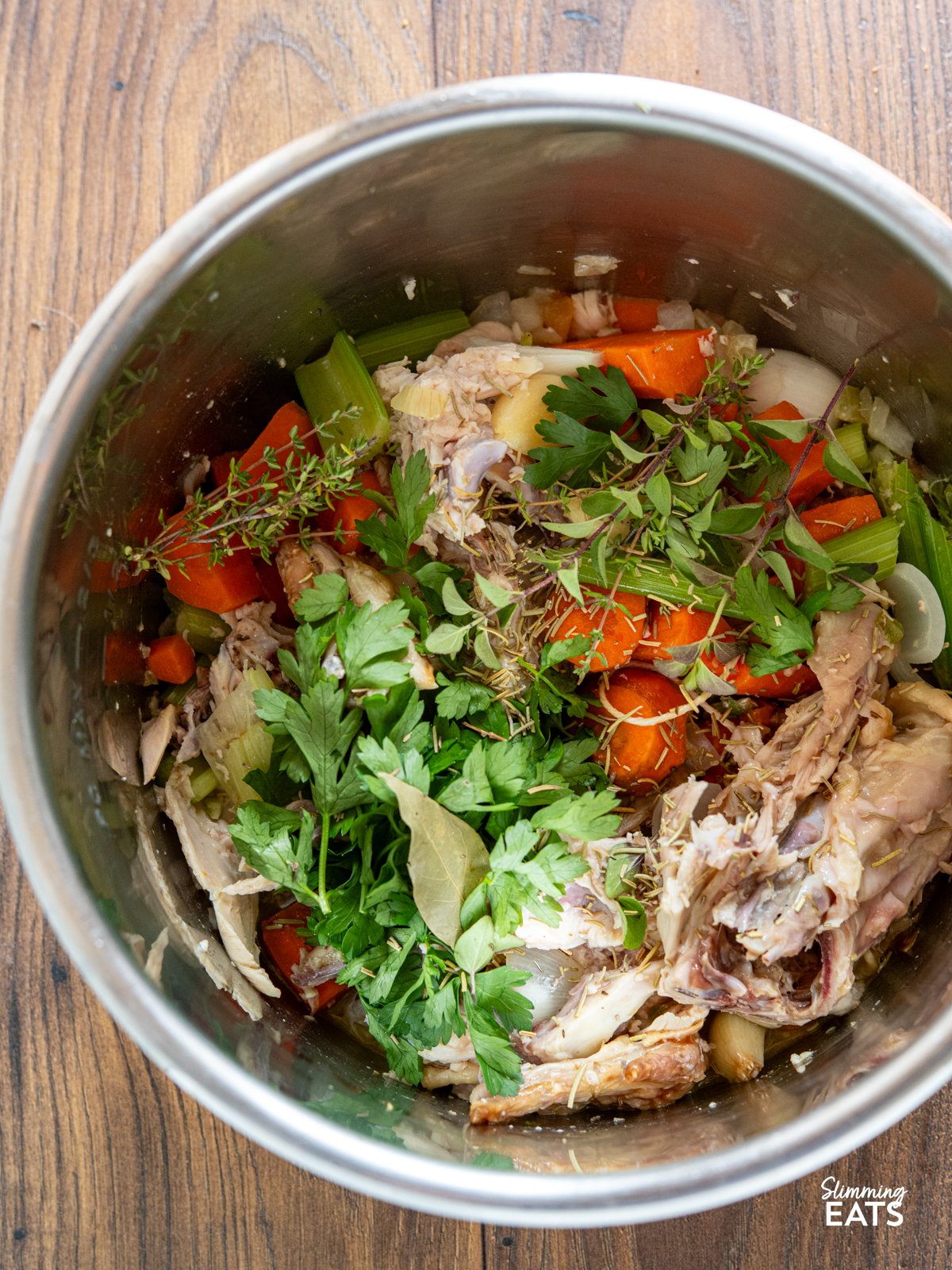 ingredients for homemade chicken bone broth in the pot of a pressure cooker ready to start cooking.