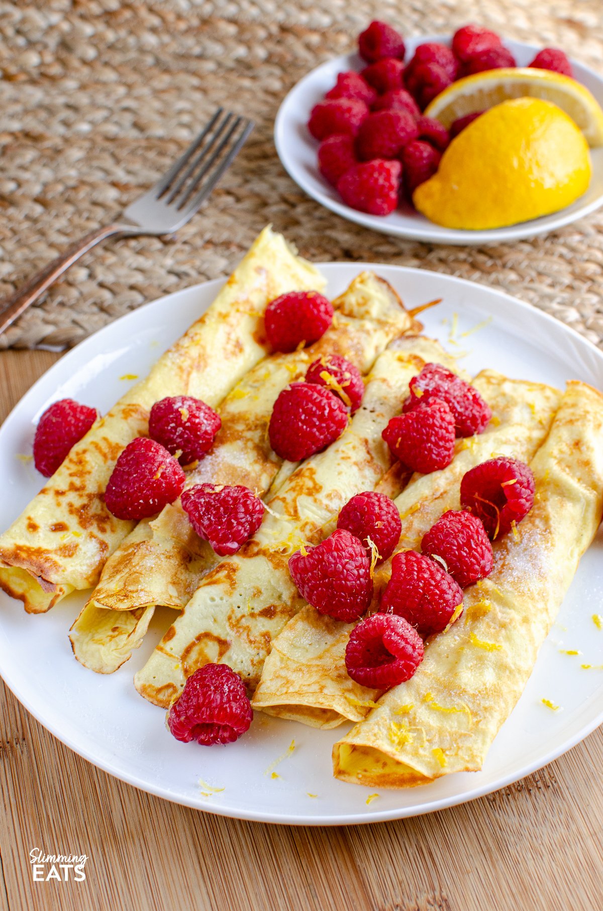 Low Syn Crepe Style Pancakes - vegetarian, Slimming World and Weight Watchers friendly Delicious Low Calorie Crepe Style Pancakes - with fresh raspberries and a little juice and zest of lemon.
