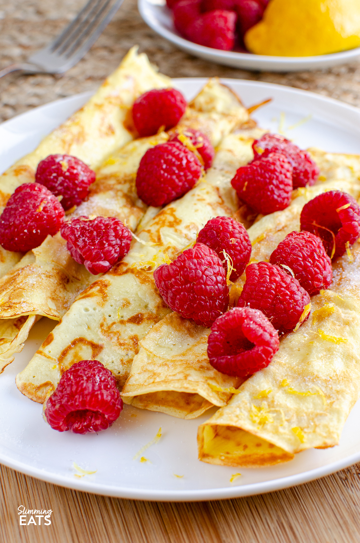 Delicious Low Calorie Crepe Style Pancakes -  with fresh raspberries and a little juice and zest of lemon. 