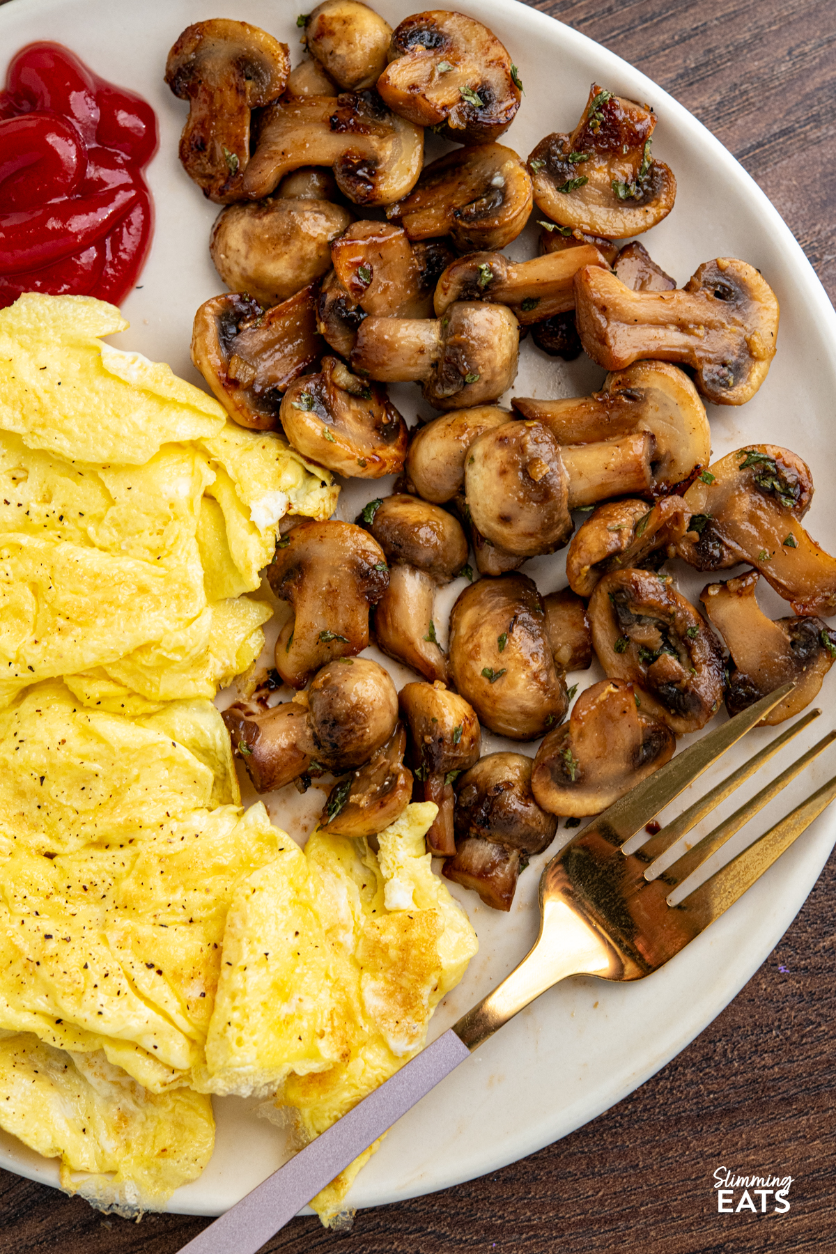 sauteed mushrooms with eggs and ketchup on a plate