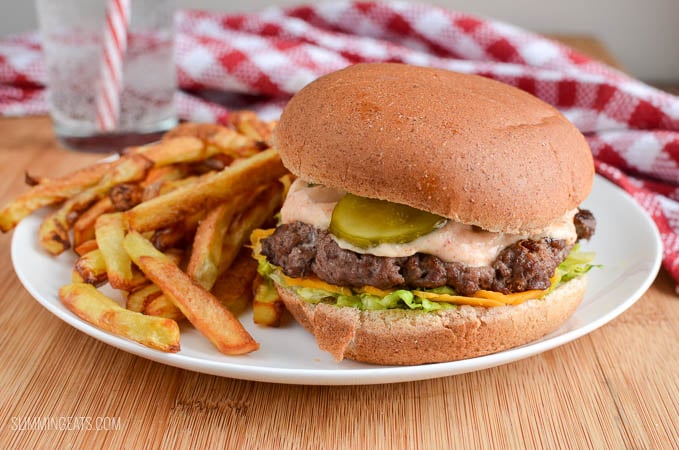 lighter version of big mac and fries fakeaway on a white plate with glass of water and red and white napkin