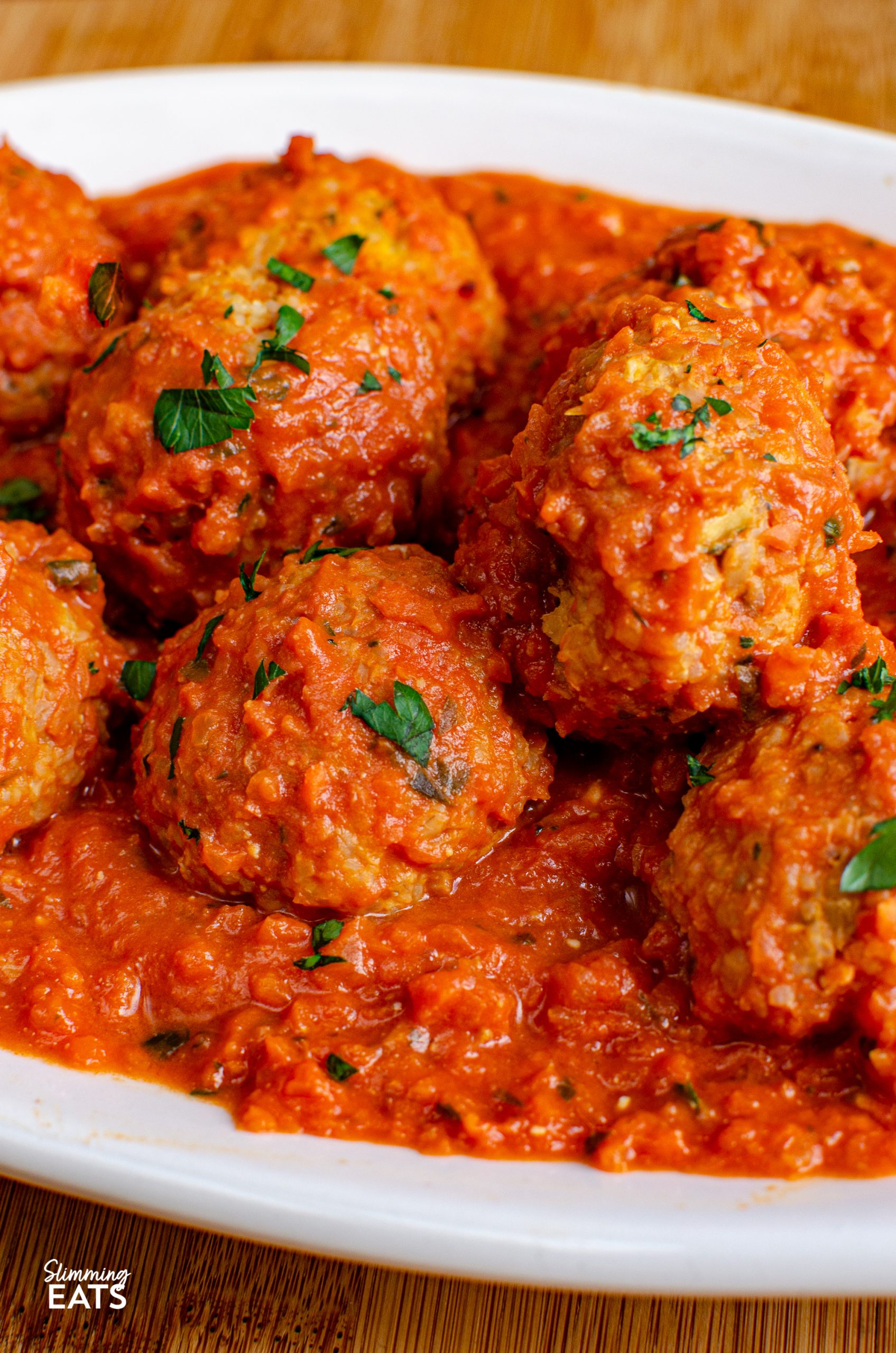 close up  of Vegetarian Meatballs in Creamy Tomato Sauce  on white oval plate