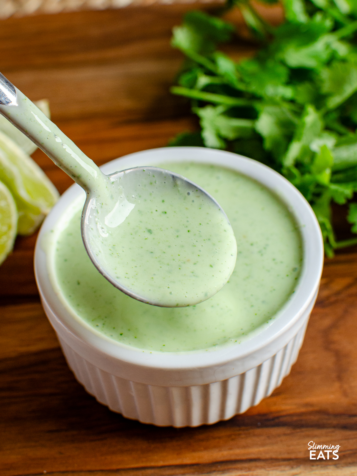 spooning some lime cilantro yoghurt dressing from a small ramekin