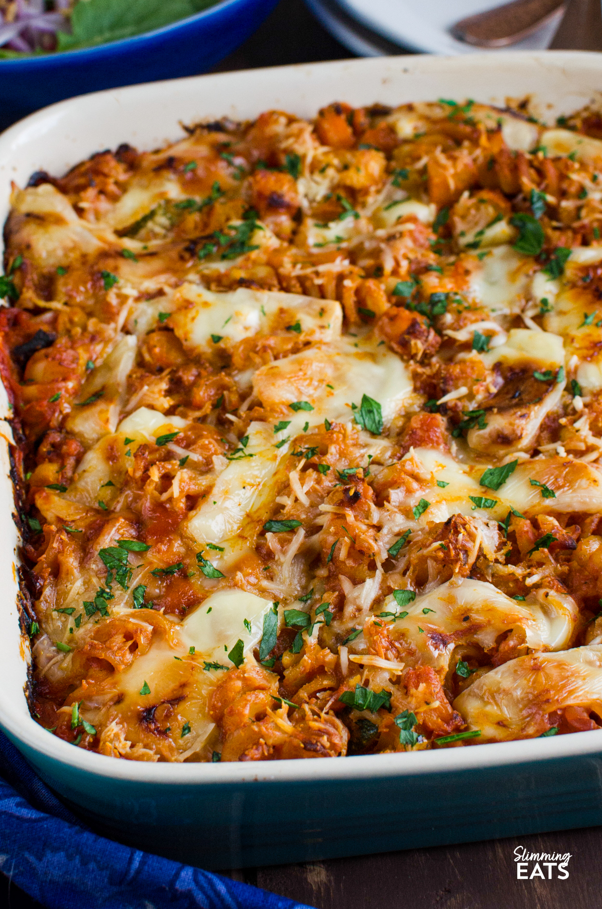 Roasted Butternut Squash Zucchini Pasta Bake - a simple comforting pasta bake with roasted butternut squash, zucchini and pasta baked in a tomato sauce with a delicious cheesy topping. It is an easy family friendly dinner that comes together with very little fuss and is perfect for busy evenings. close up of Roasted Butternut Squash Zucchini Pasta Bake in ceramic baking dish