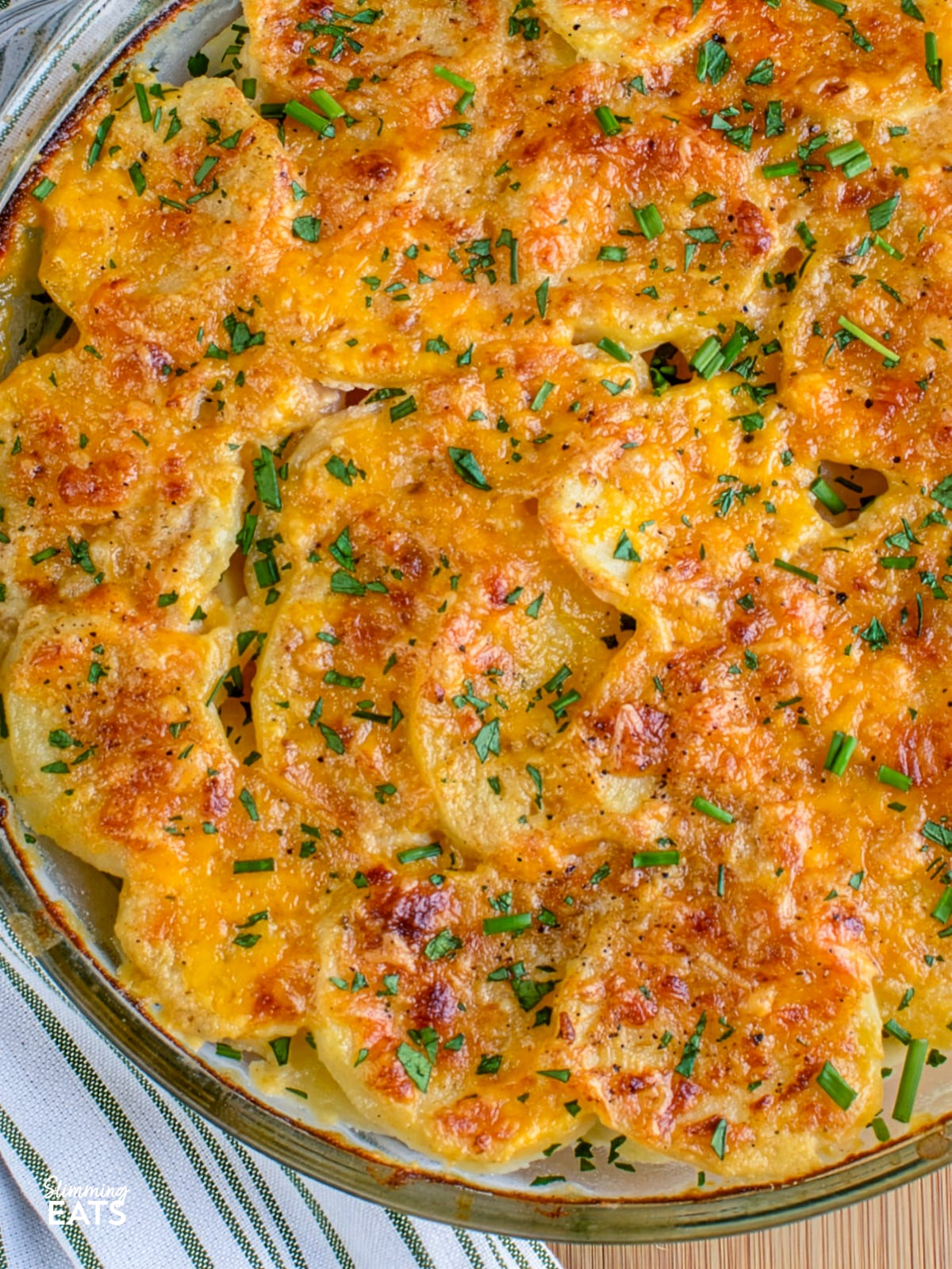 close up of scalloped potatoes baked and out of oven in a glass round dish