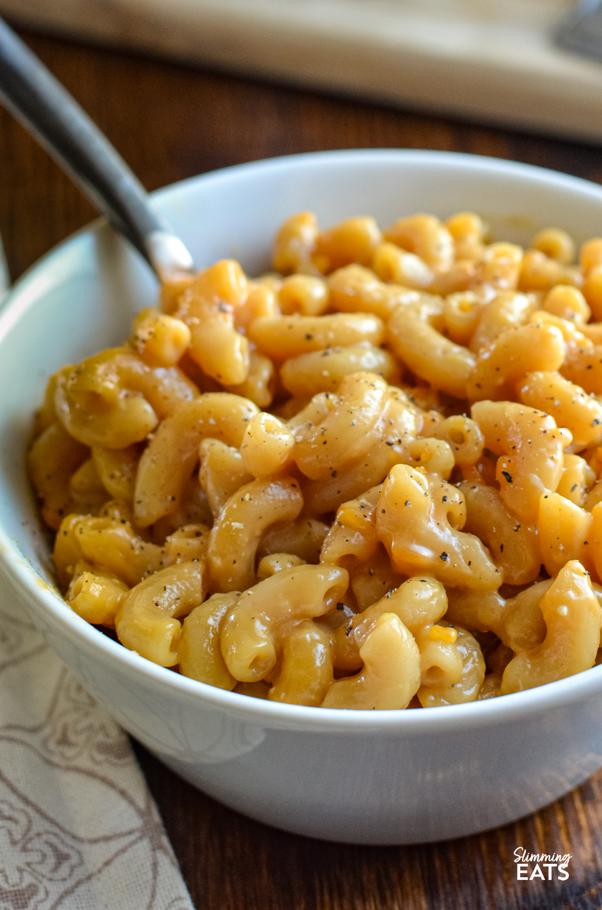 marmite mac and cheese serving in a white bowl with fork
