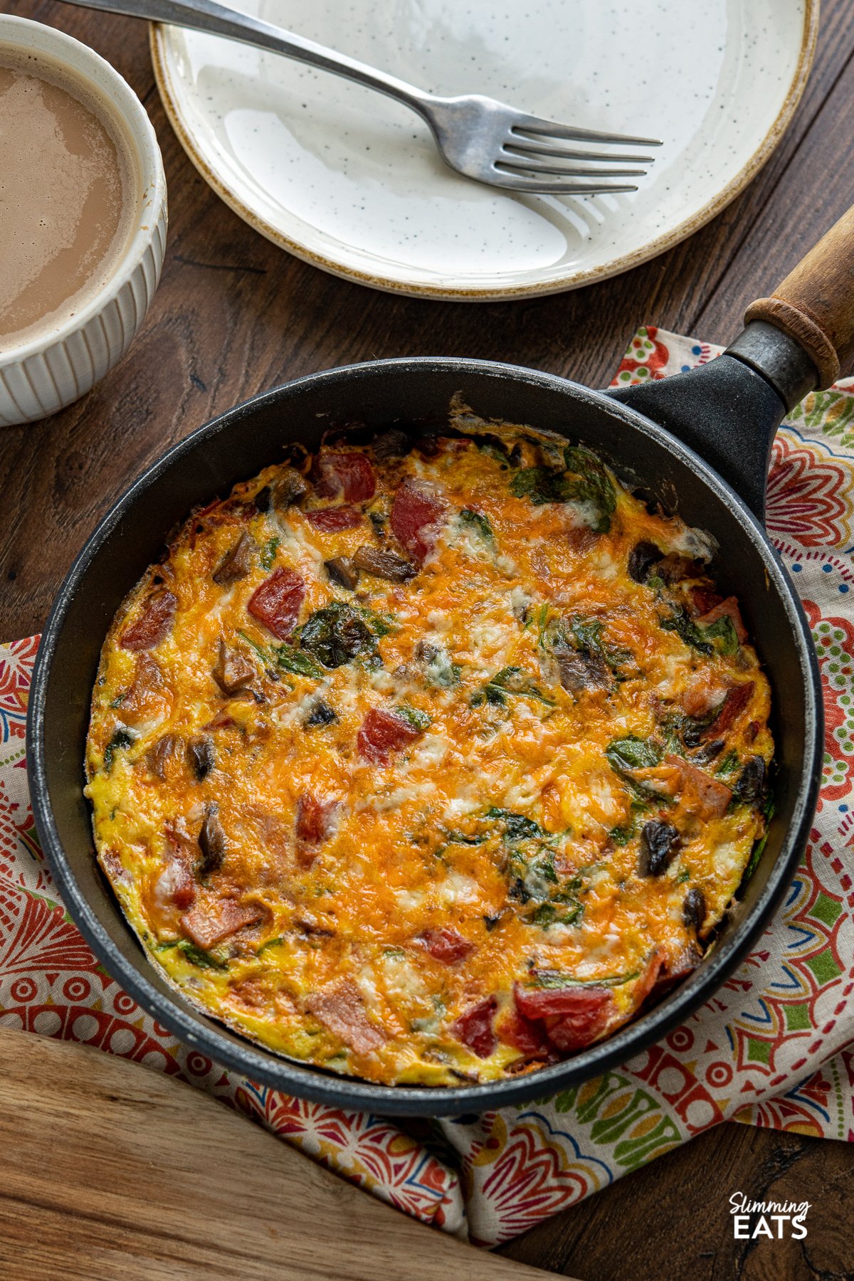 Start your day with this quick and delicious Speedy Breakfast Frittata with bacon, tomatoes, spinach all finished off with a little cheddar Speedy Breakfast Frittata in pan with wooden handle