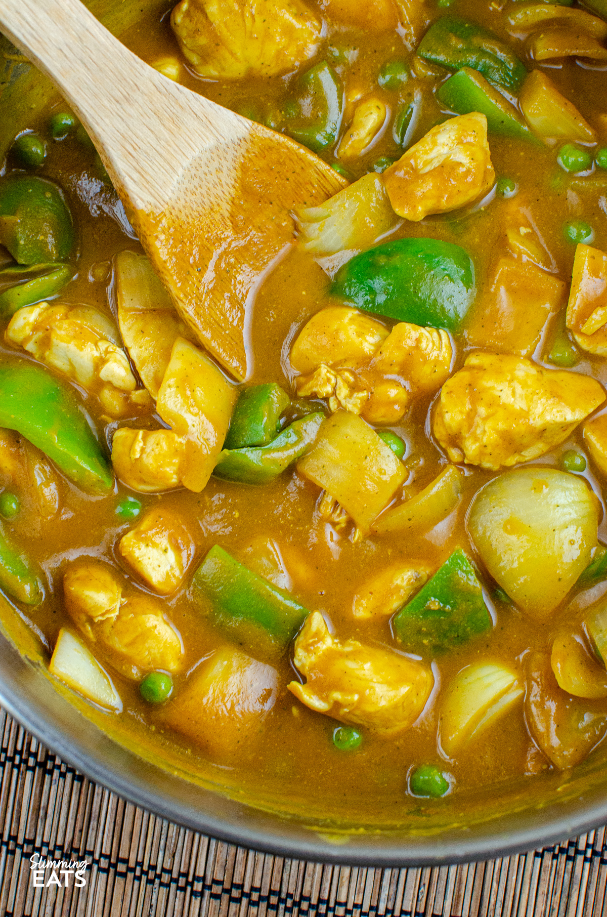 close up of Chinese Chicken Curry in stainless steel frying pan with wooden spoon
