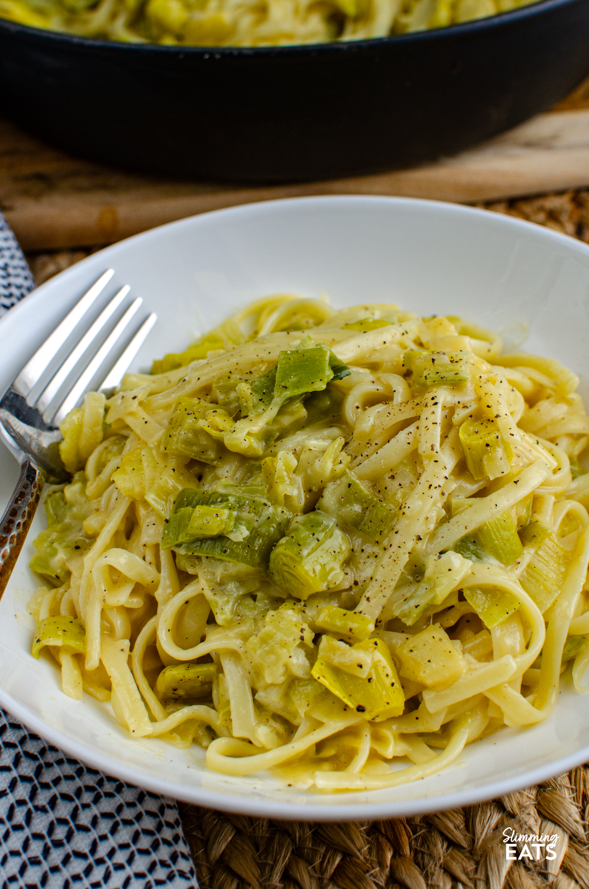 serving of Creamy Cheesy Leek Pasta in white bowl with fork