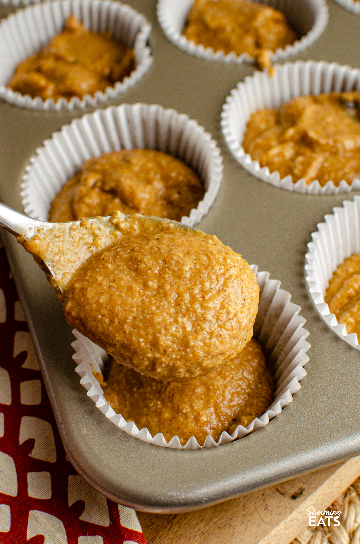 Pumpkin Sultana Muffins batter being spooned into muffin cases