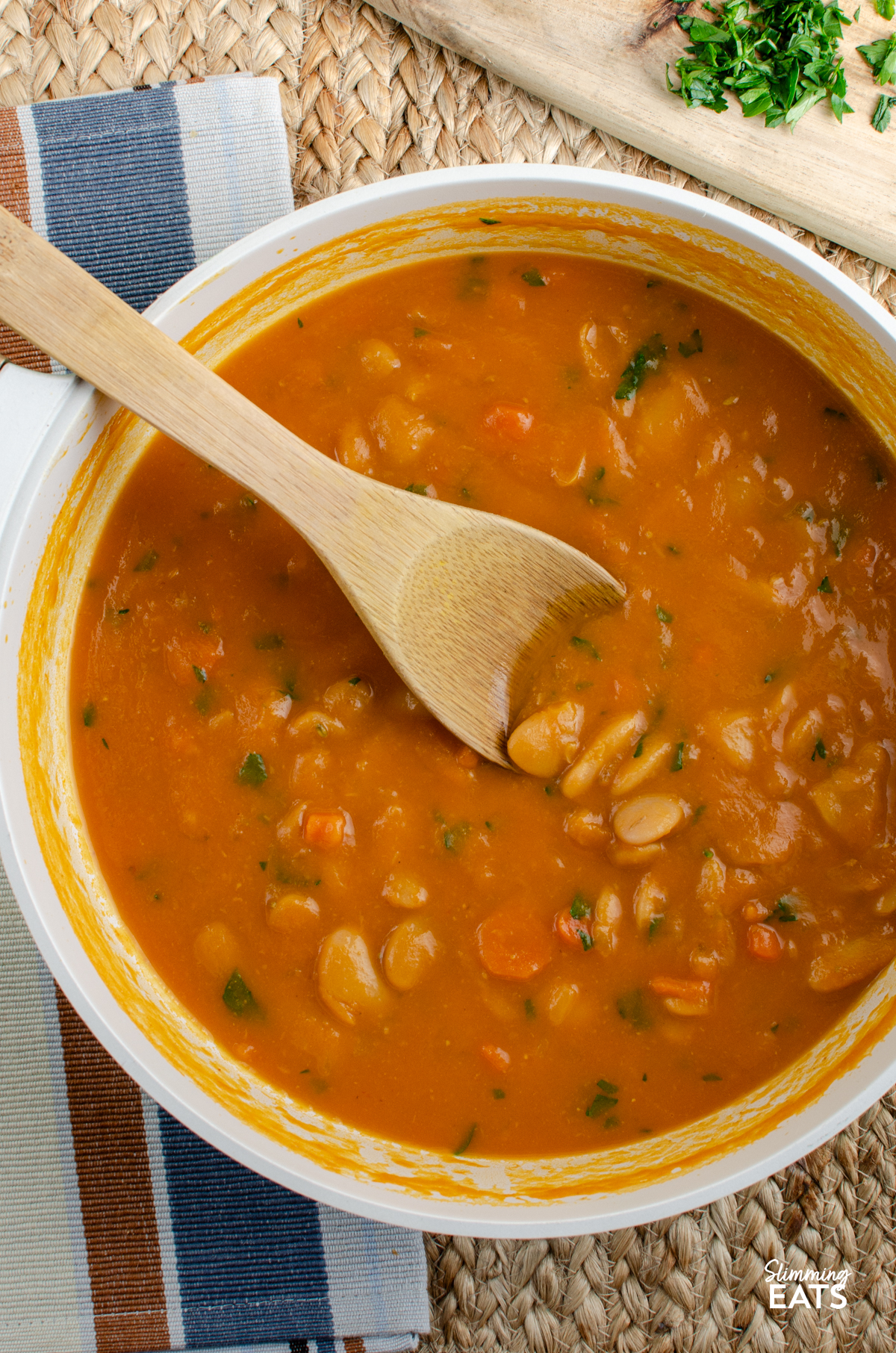 Carrot and Butter Bean Soup - a simple comforting soup with sweet carrots and creamy butter beans blended into a smooth flavour packed bowl that is perfect for lunch or a light dinner. It is quick to make, filling and delicious served with some warm crusty bread on the side. Carrot and Butter Bean Soup in a double wooden handled ceramic non stick pan with wooden spoon