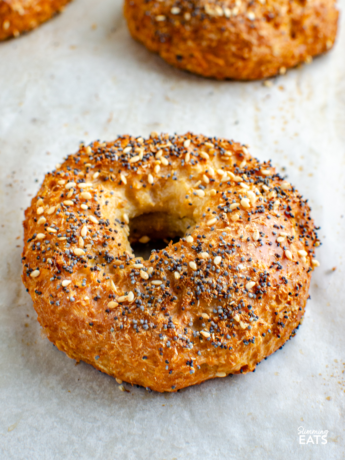 cooked oat bagel with bagel seasoning on parchment paper