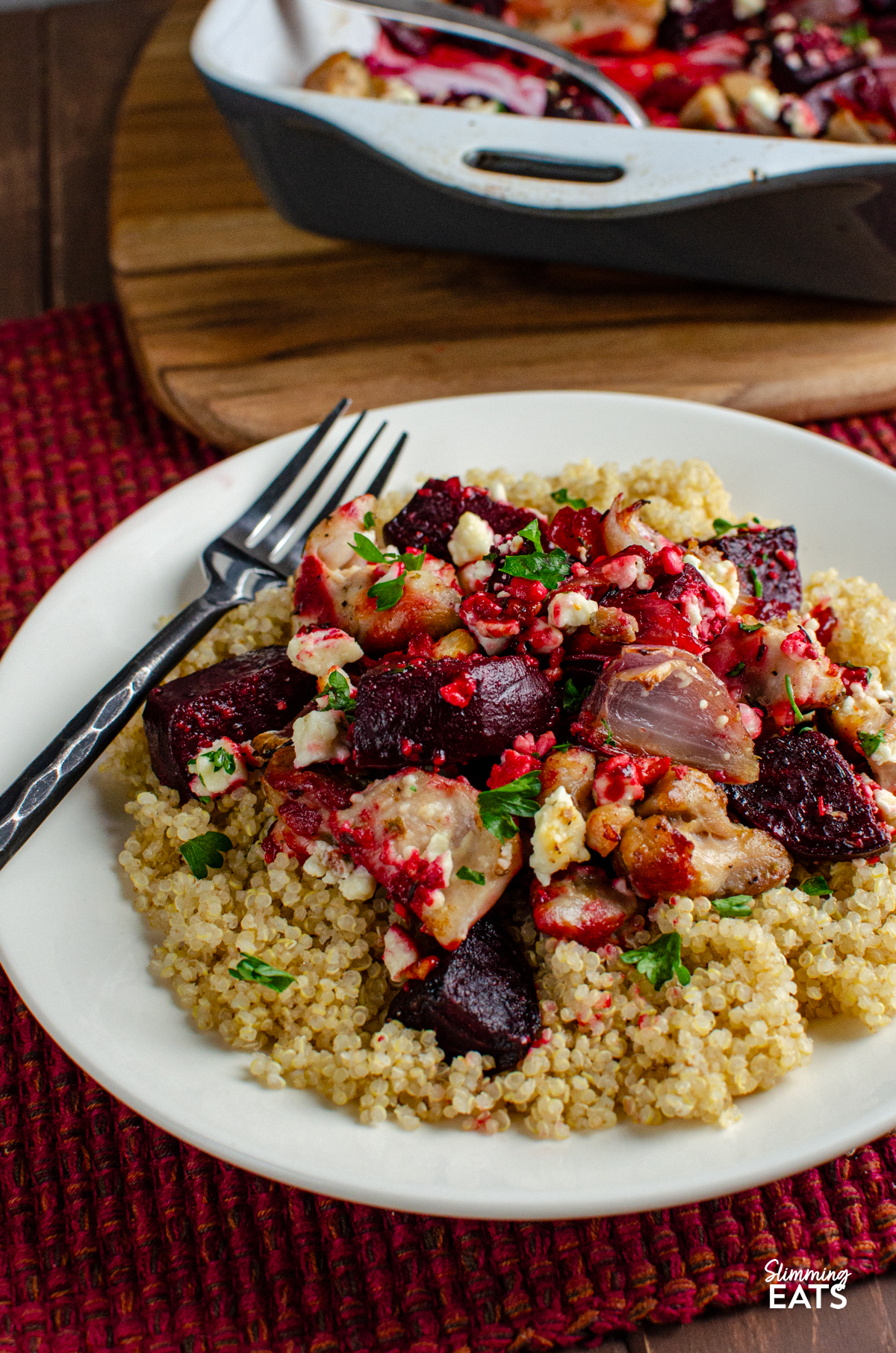 serving of Chicken, Feta and Roasted Beetroot Bake on cooked quinoa on a white plate with a fork placed on left