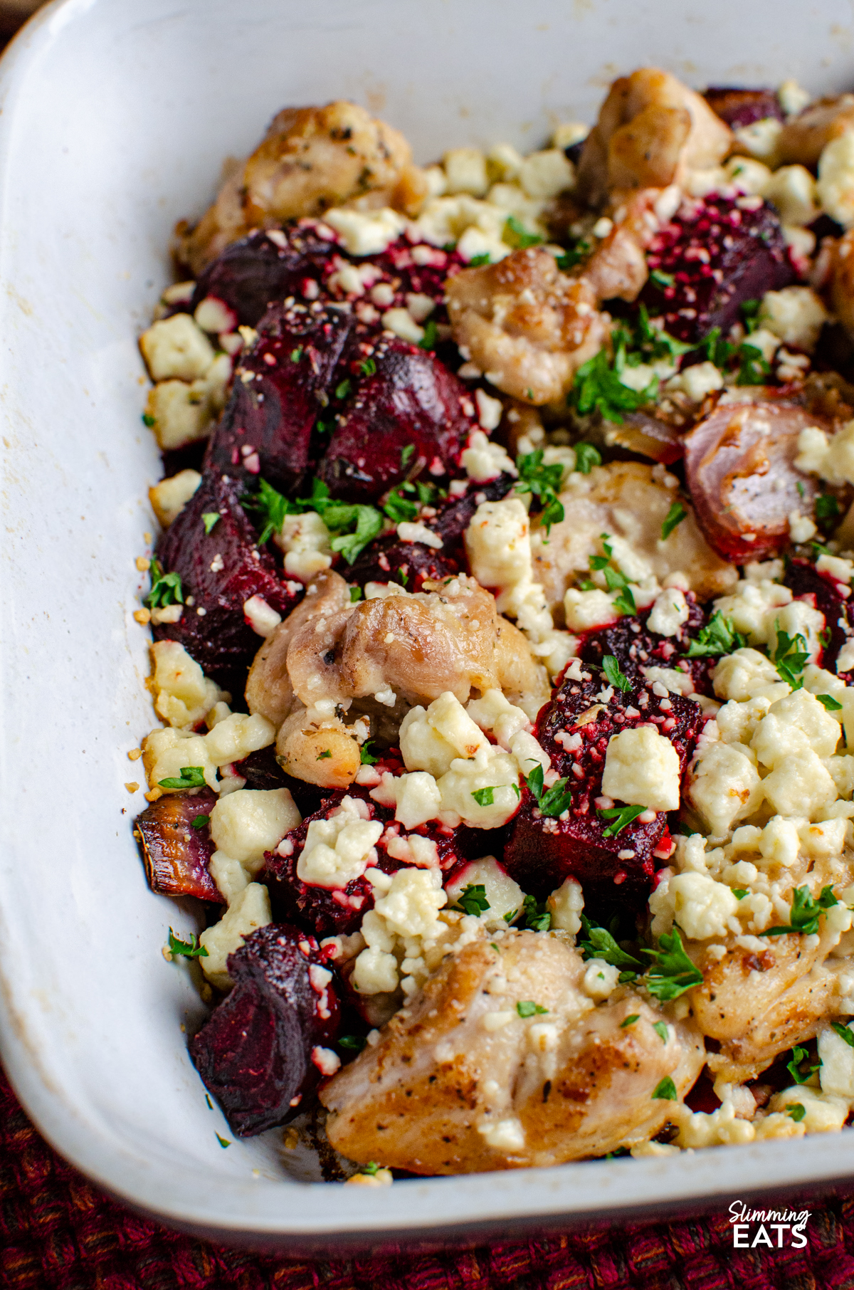 close up of Chicken, Feta and Roasted Beetroot Bake in a grey and white ceramic baking dish