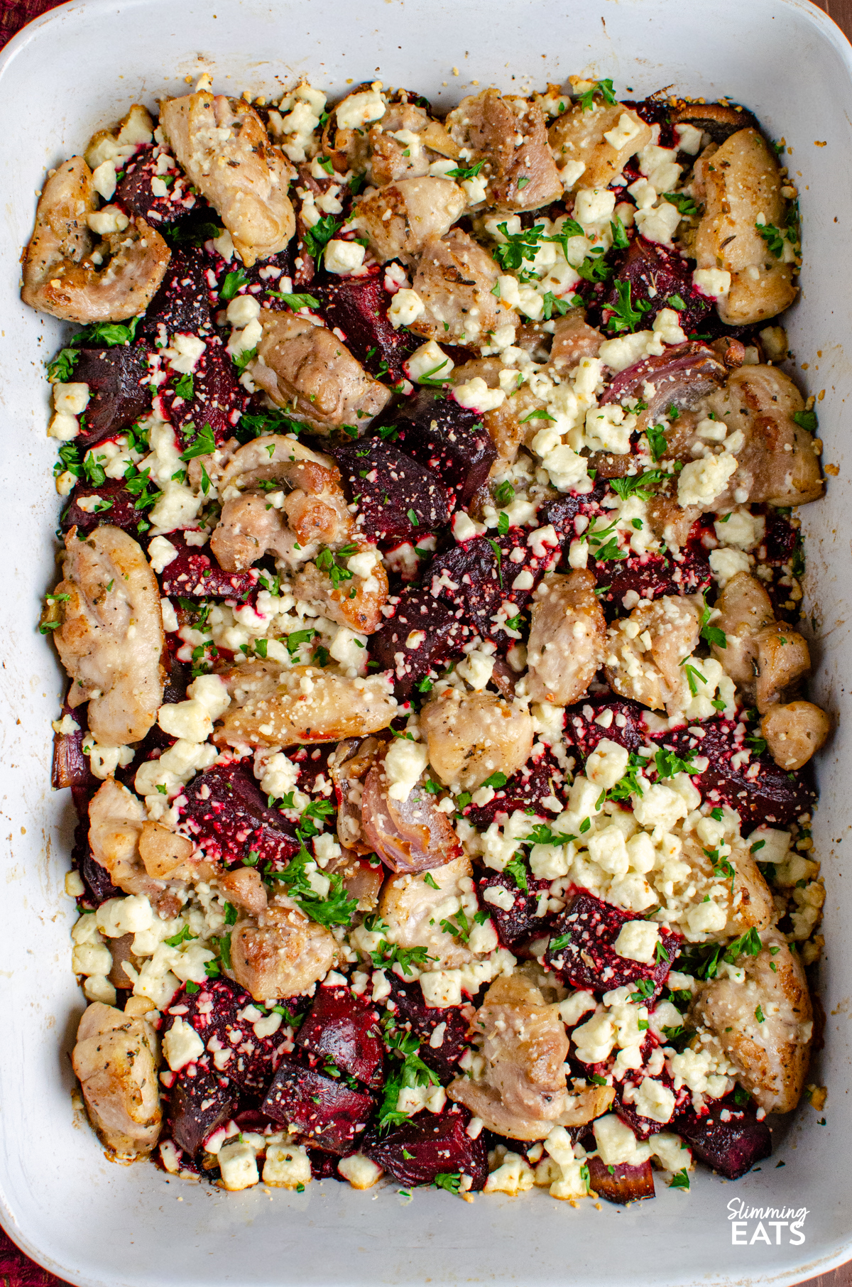 close up of Chicken, Feta and Roasted Beetroot Bake in a grey and white ceramic baking dish