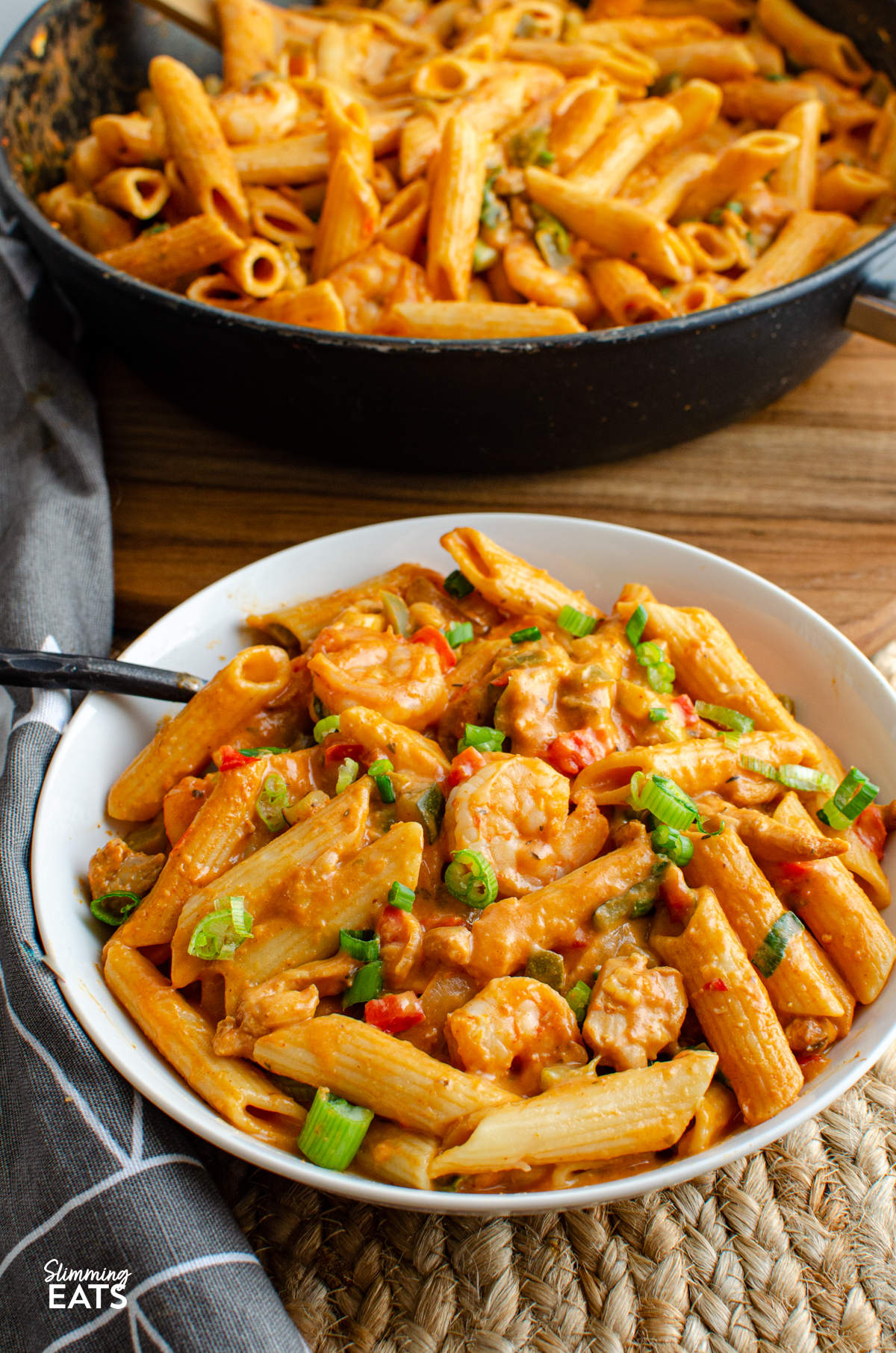 white bowl with One Pot New Orleans Cajun Pasta, chicken, pasta and shrimp visible