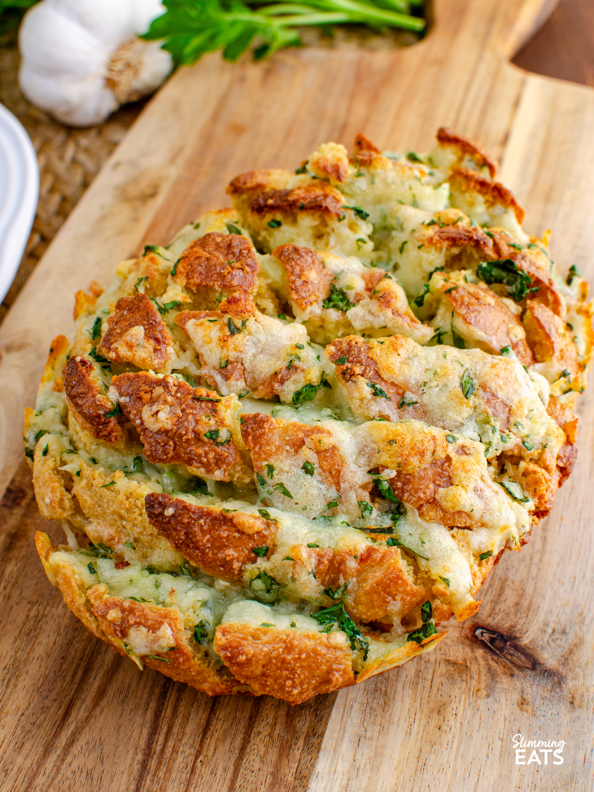 out of oven cheesy oat garlic bread on a wooden board