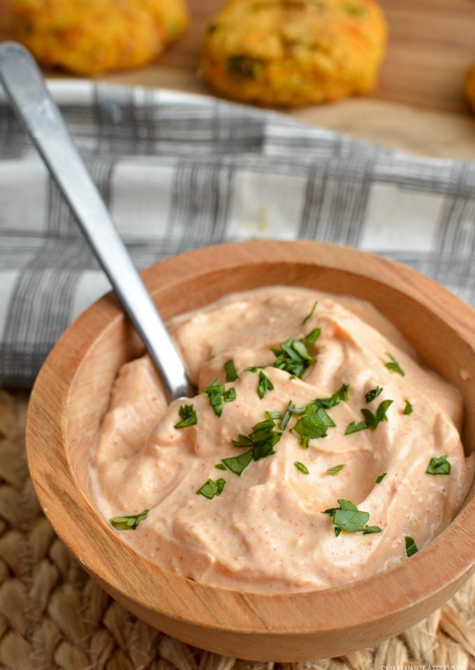 Louisiana remoulade dip in wooden bowl with patties in background with spoon