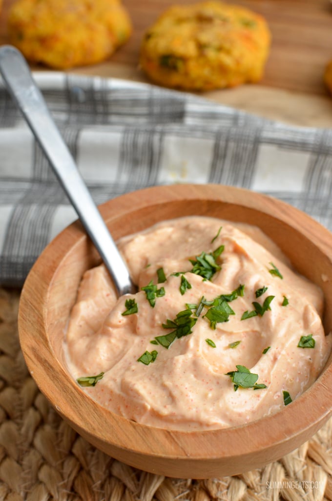 Louisiana remoulade dip in wooden bowl with patties in background with spoon